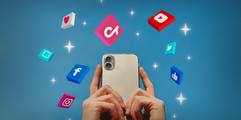 Unas manos sosteniendo un teléfono celular, alrededor aparecen los logos de TikTok, YouTube, Twitter, Facebook, Instagram y los iconos de like, me gusta y share. 
